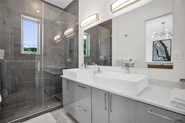 a bathroom with a sink a shower and a mirror