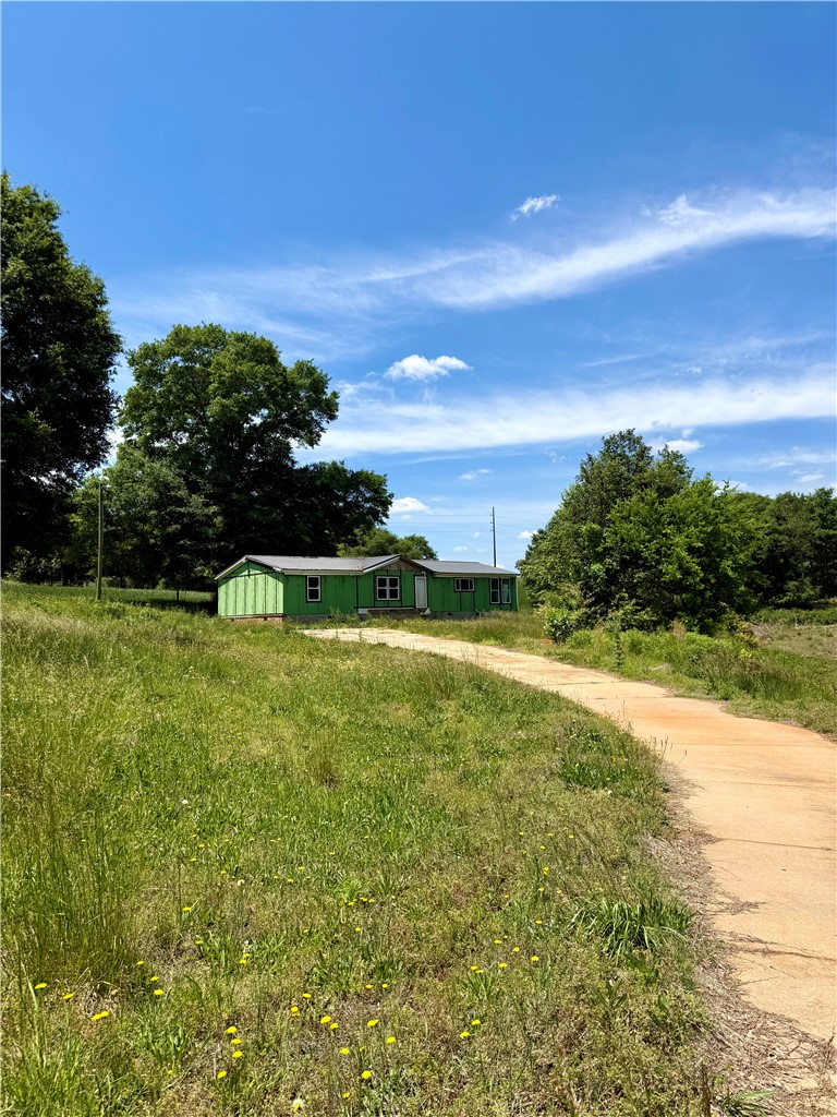 This verdant property features a residential structure and ample outdoor space with natural landscaping.