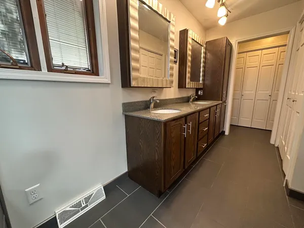 a bathroom with a granite countertop sink and a toilet