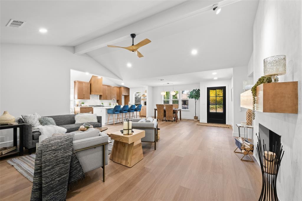 Living room featuring beam ceiling, light wood-style flooring, recessed lighting, a ceiling fan, and a fireplace