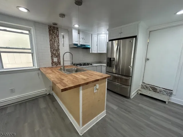 a kitchen with a refrigerator sink and cabinets
