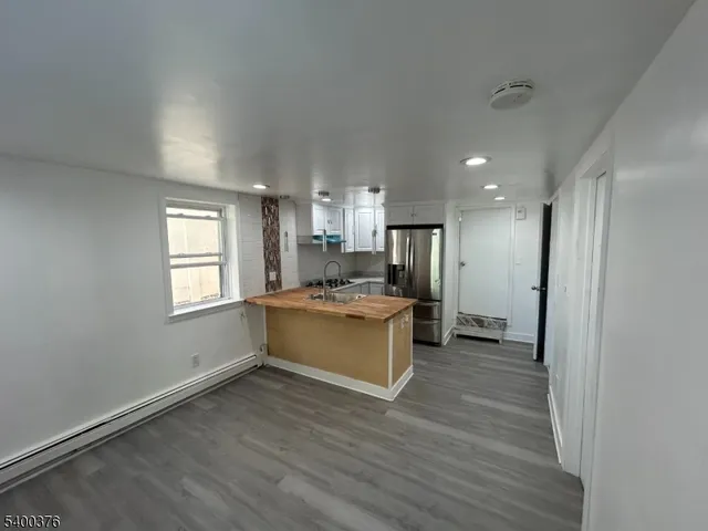 a large kitchen with a refrigerator and a stove top oven
