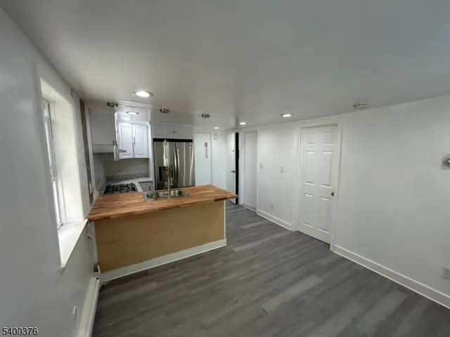 a view of kitchen with refrigerator stove and wooden floor