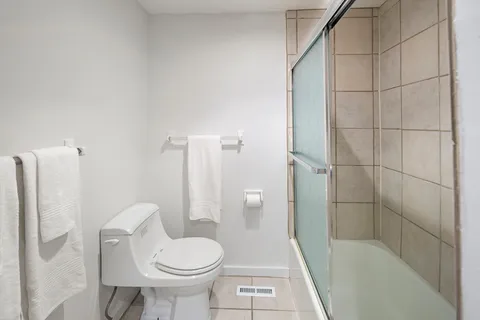 a bathroom with a toilet and a shower