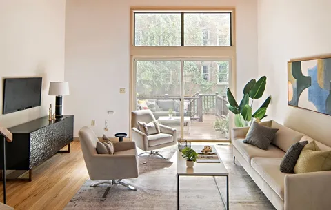 a living room with furniture a flat screen tv and a large window
