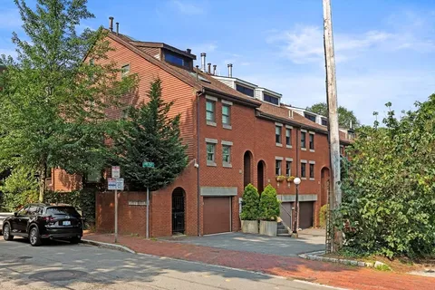 a front view of a building with a garden and plants