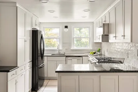 a kitchen with granite countertop a sink stainless steel appliances and cabinets