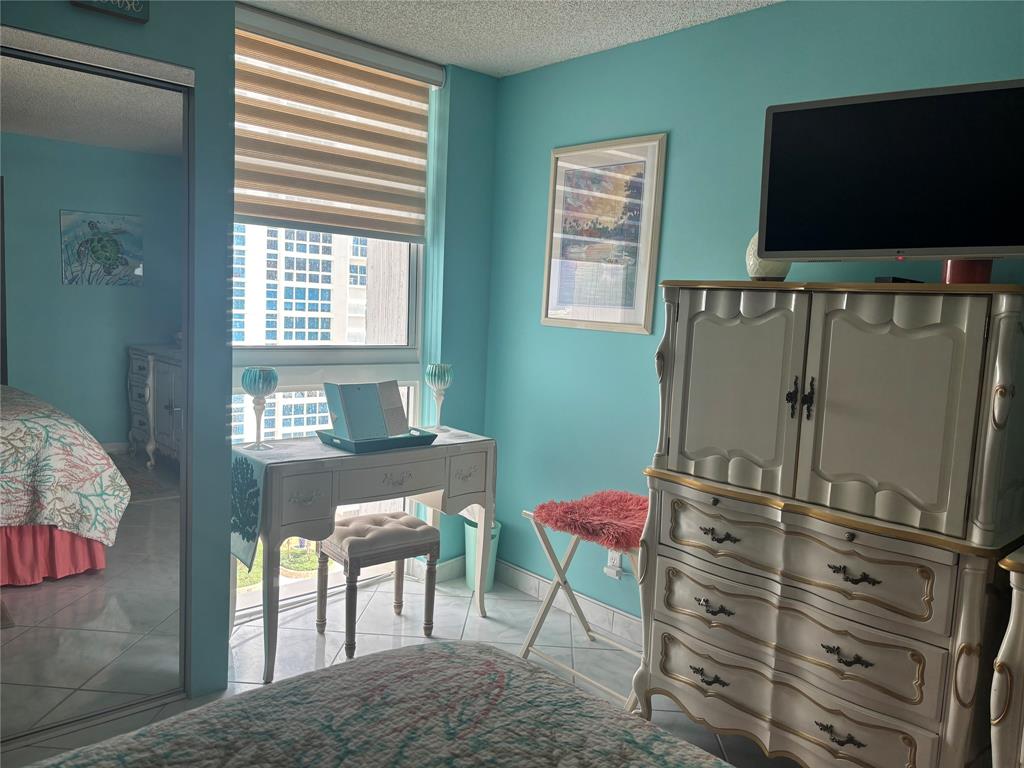 1370 South Ocean Boulevard, Unit 1005 Pompano Beach, FL 33062 - Photo 11 of 27 a bedroom with a bed and a flat screen tv