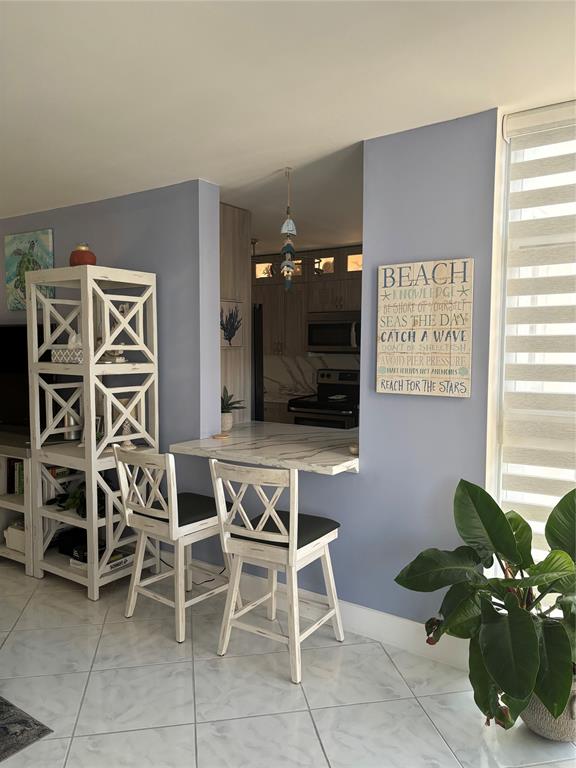 1370 South Ocean Boulevard, Unit 1005 Pompano Beach, FL 33062 - Photo 14 of 27 a living room with furniture a flat screen tv and a window