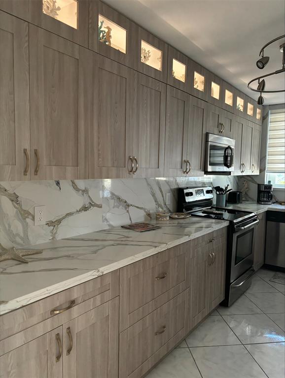 1370 South Ocean Boulevard, Unit 1005 Pompano Beach, FL 33062 - Photo 7 of 27 a kitchen with stainless steel appliances granite countertop a stove a sink and a microwave