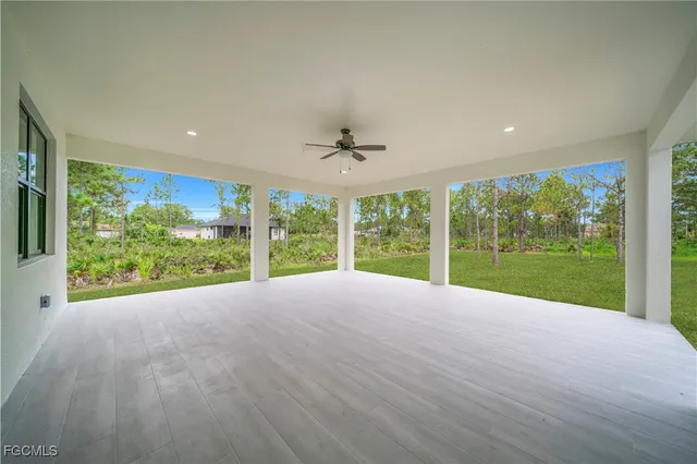 a view of an empty room with a ceiling fan and window