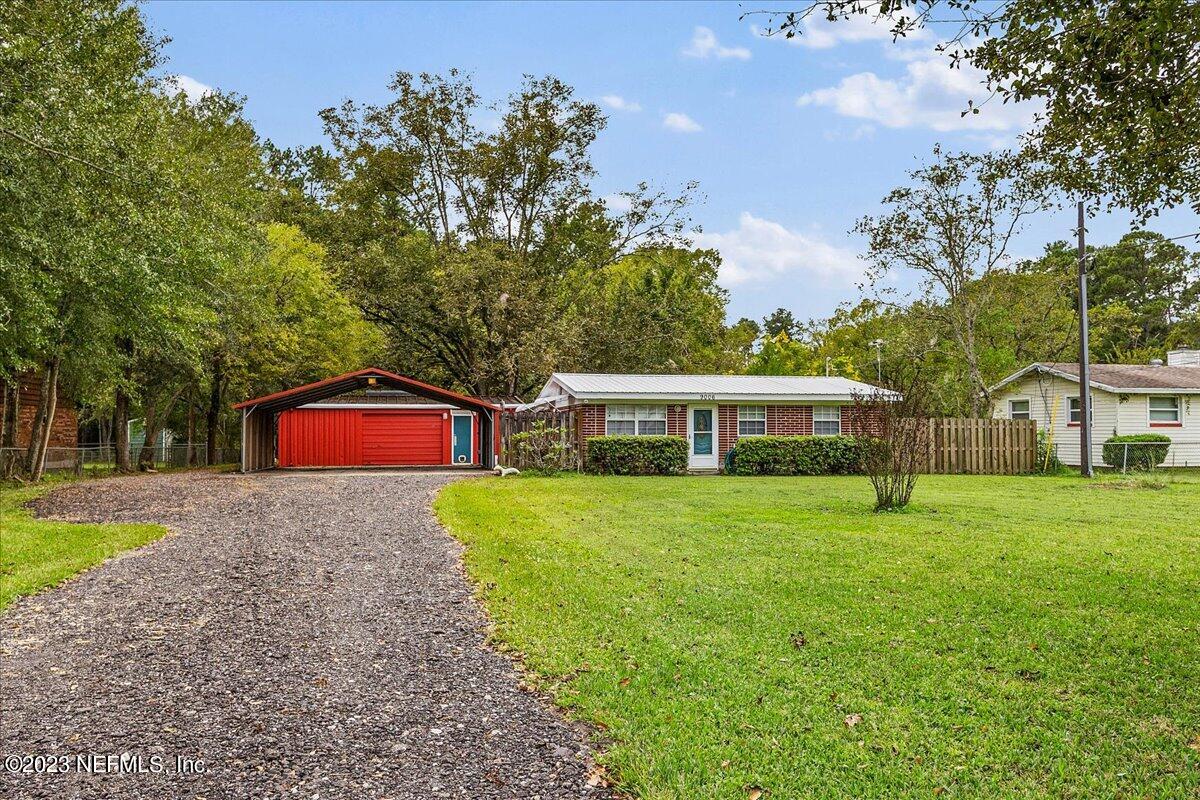 9006 Marlee Road Jacksonville, FL 32222 - Photo 1 of 18 a front view of a house with a yard and trees