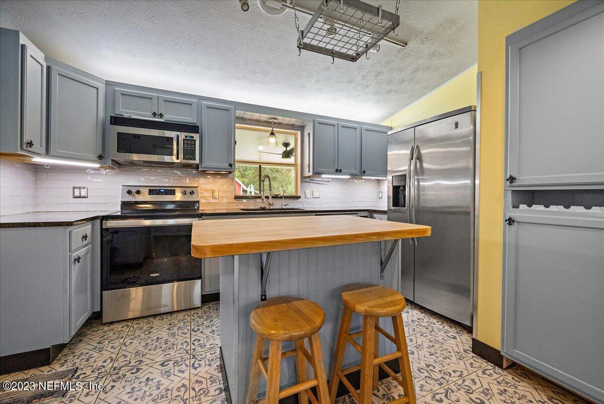 9006 Marlee Road Jacksonville, FL 32222 - Photo 3 of 18 a kitchen with stainless steel appliances a stove a sink and a refrigerator