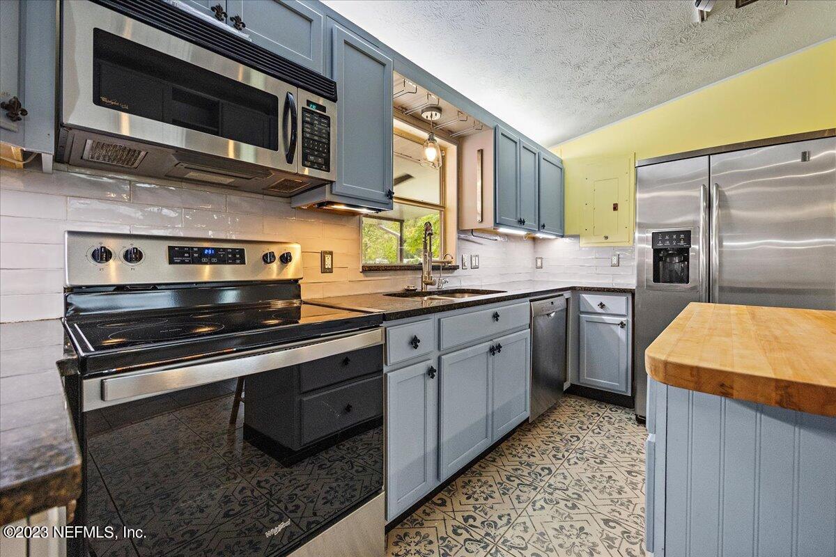9006 Marlee Road Jacksonville, FL 32222 - Photo 4 of 18 a kitchen with stainless steel appliances kitchen island granite countertop a sink stove and microwave