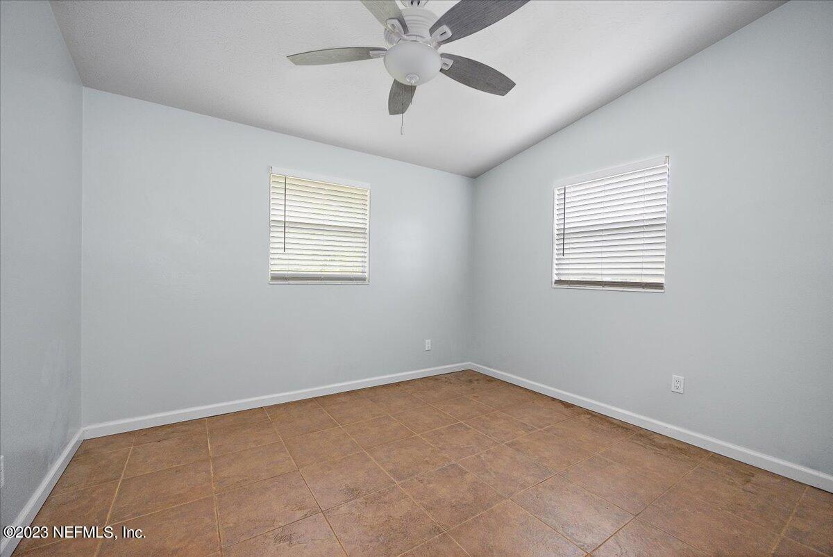 9006 Marlee Road Jacksonville, FL 32222 - Photo 7 of 18 an empty room with a window and a fan