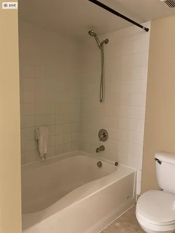 a white bath tub sitting next to a white toilet and a shower