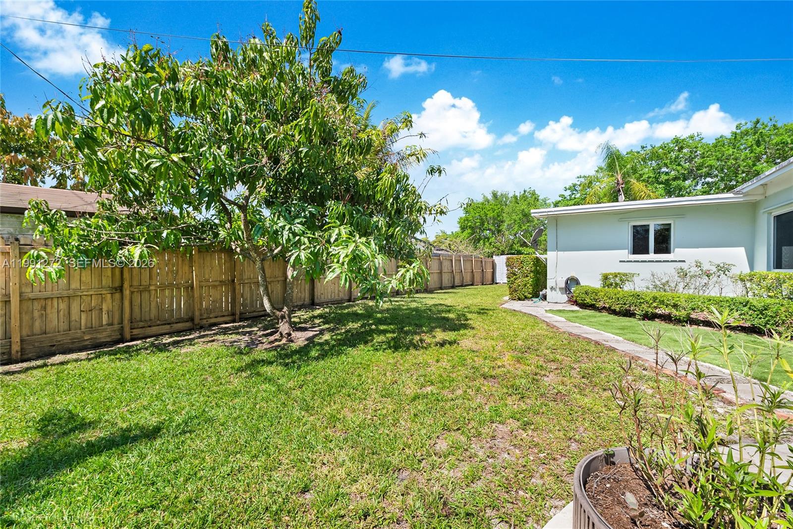 8535 Southwest 97th Road Miami, FL 33173 - Photo 23 of 28 a backyard of a house with plants and wooden fence
