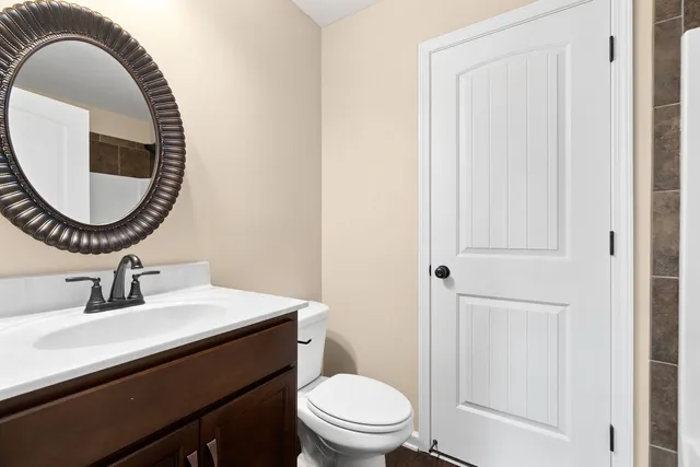 a bathroom with a toilet a sink and a mirror