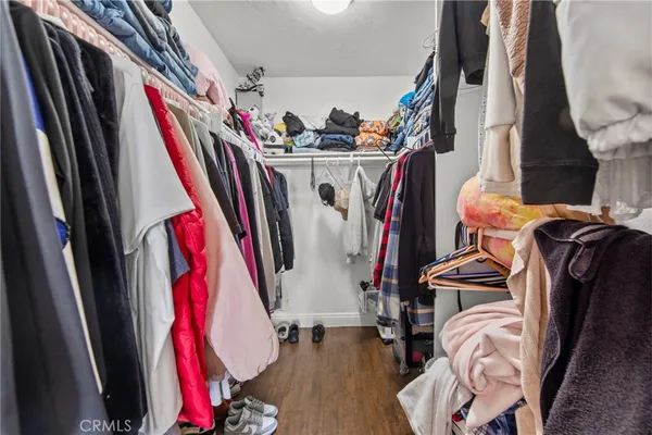 a view of walk in closet with clothes and shoes