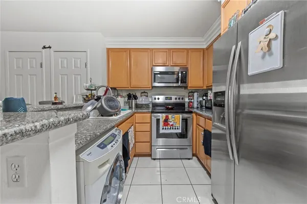 a kitchen with stainless steel appliances granite countertop a sink stove refrigerator and microwave