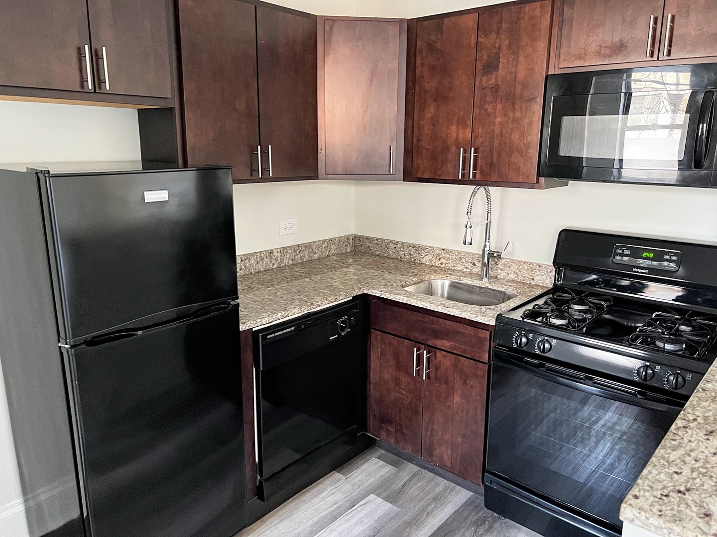 839 West Sheridan Road, Unit 204 Chicago, IL 60613 - Photo 5 of 13 a kitchen with granite countertop a refrigerator stove and microwave
