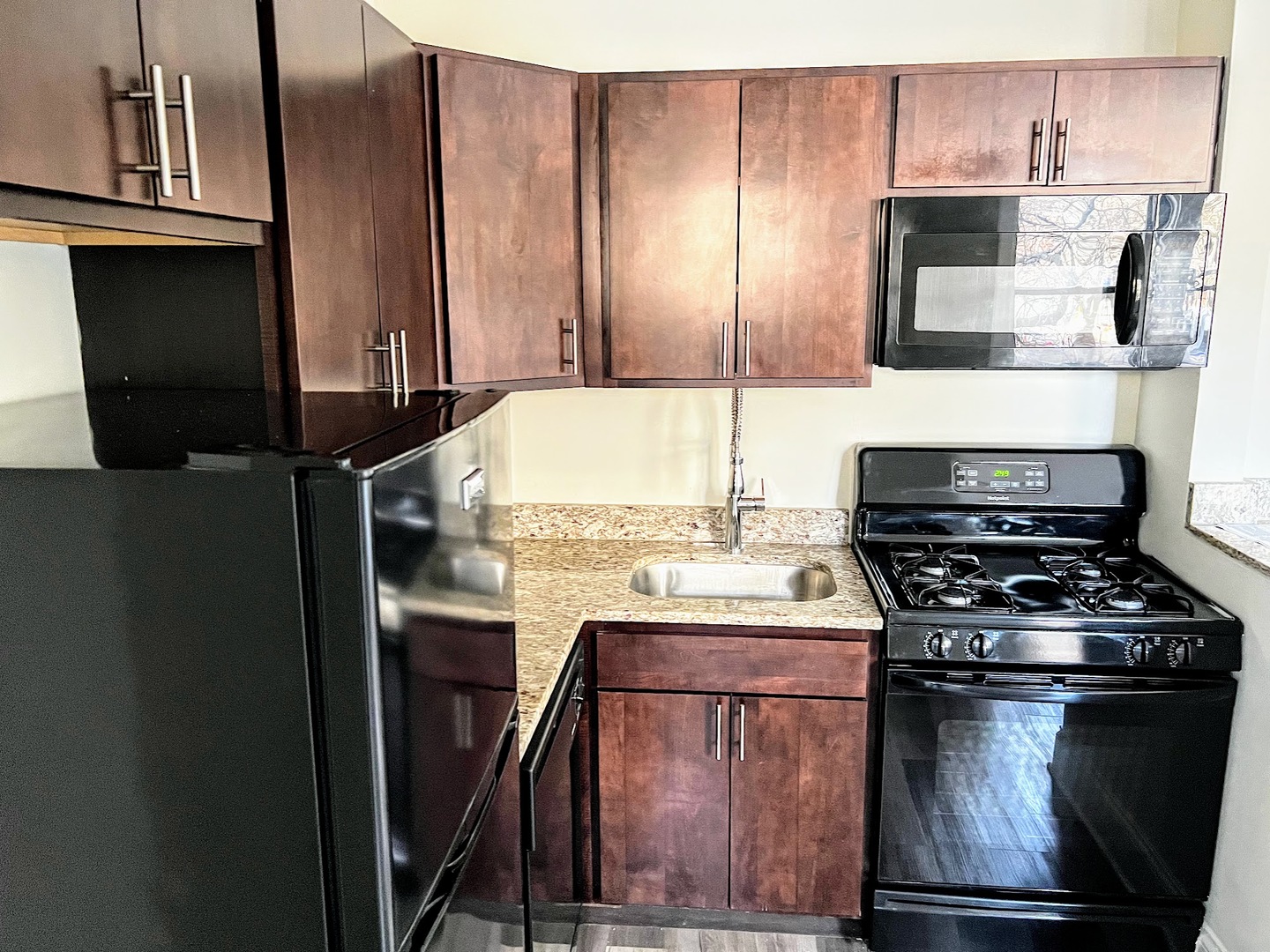 839 West Sheridan Road, Unit 204 Chicago, IL 60613 - Photo 7 of 13 a kitchen with granite countertop a stove and a refrigerator