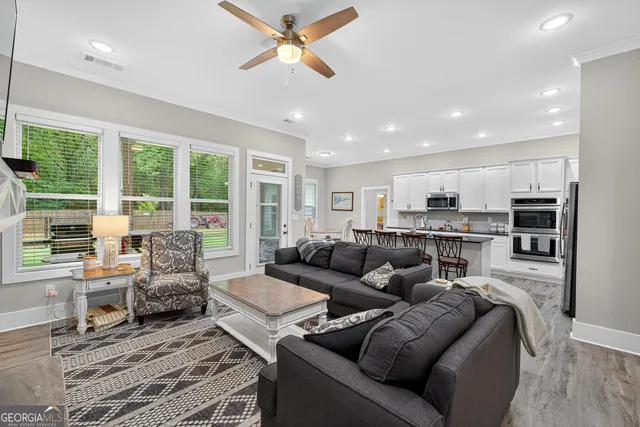 a kitchen with stainless steel appliances wooden floors and white cabinets