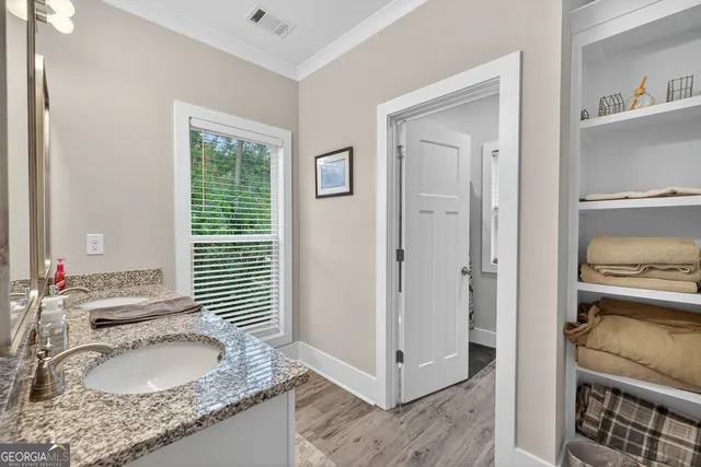 a open kitchen with stainless steel appliances granite countertop a stove top oven a sink dishwasher a dining table and chairs with wooden floor