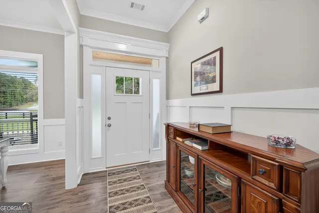 a view of a dining room and livingroom with furniture wooden floor a rug and a painting