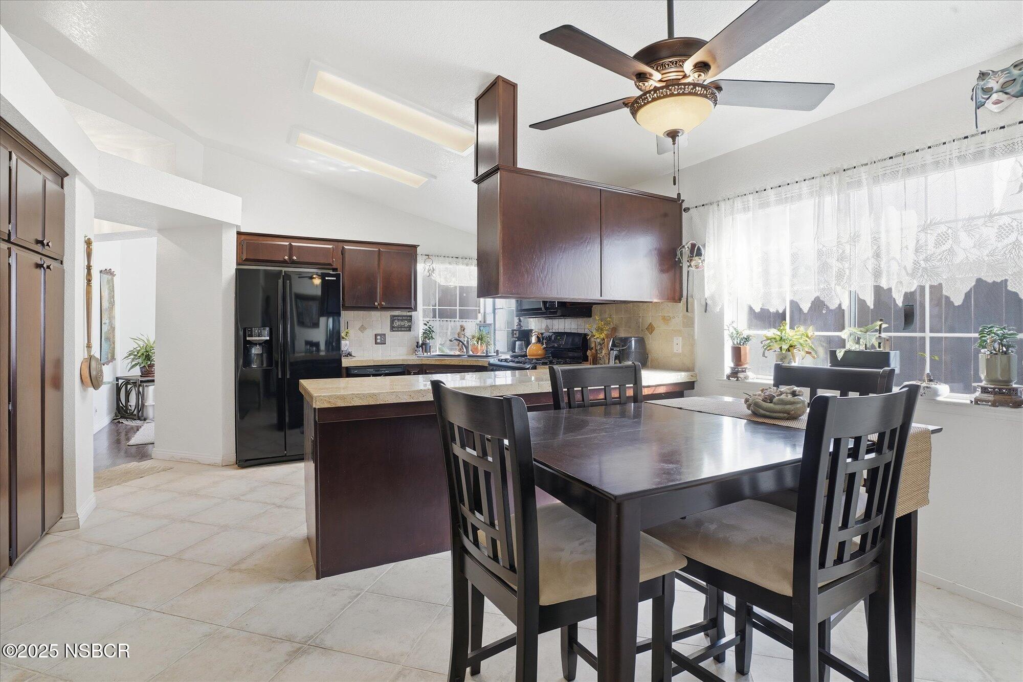 4300 Ridgecrest Street Santa Maria, CA 93455 - Photo 11 of 40 a kitchen with a dining table chairs stainless steel appliances cabinets and a sink