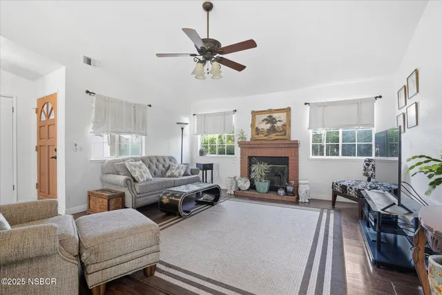 a living room with furniture fireplace and a large window