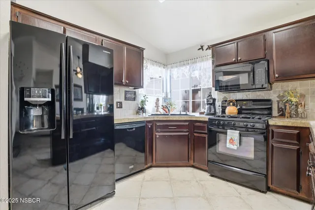 a kitchen with stainless steel appliances granite countertop a stove refrigerator and cabinets