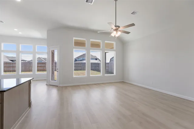 a view of kitchen with kitchen island wooden floor and refrigerator