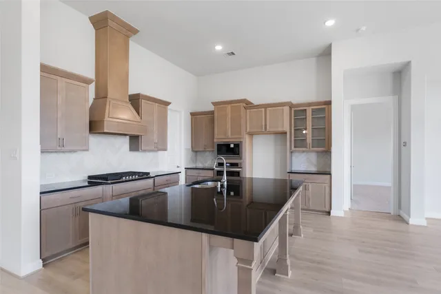 a kitchen with granite countertop a sink a stove and refrigerator