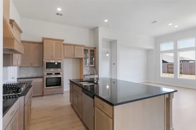 a kitchen with kitchen island granite countertop a stove and a sink