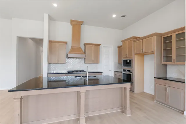 a kitchen with kitchen island granite countertop a sink and refrigerator