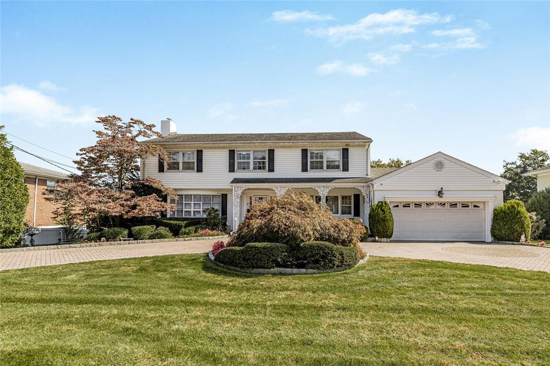 a front view of a house with a yard garage and outdoor seating