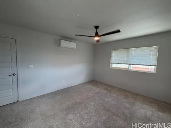 an empty room with a ceiling fan and windows