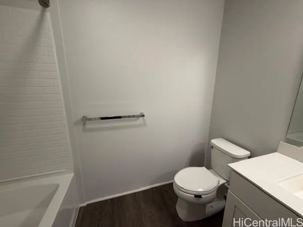 a white toilet sitting next to a white sink and vanity