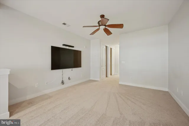 a living room with a flat screen tv and white walls