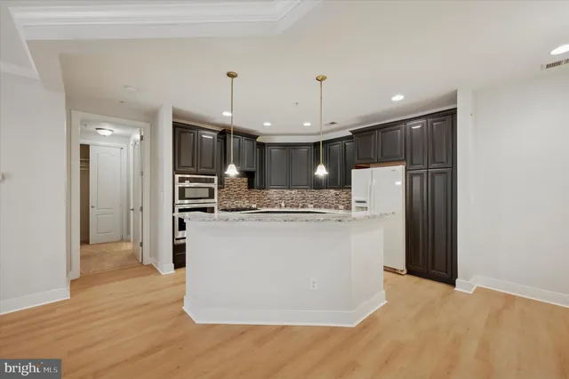 a kitchen with kitchen island a refrigerator stove a sink and a oven