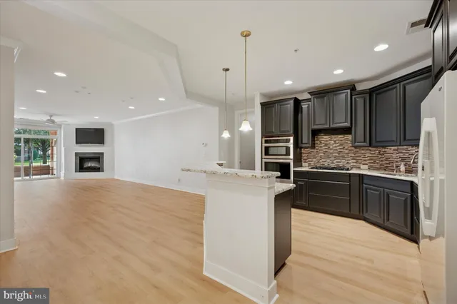 a large kitchen with kitchen island a sink stainless steel appliances and cabinets