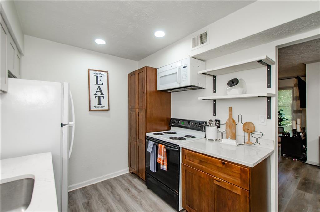 5157 Roswell Road, Unit 2 Atlanta, GA 30342 - Photo 14 of 24 a kitchen with stainless steel appliances a stove a refrigerator and cabinets