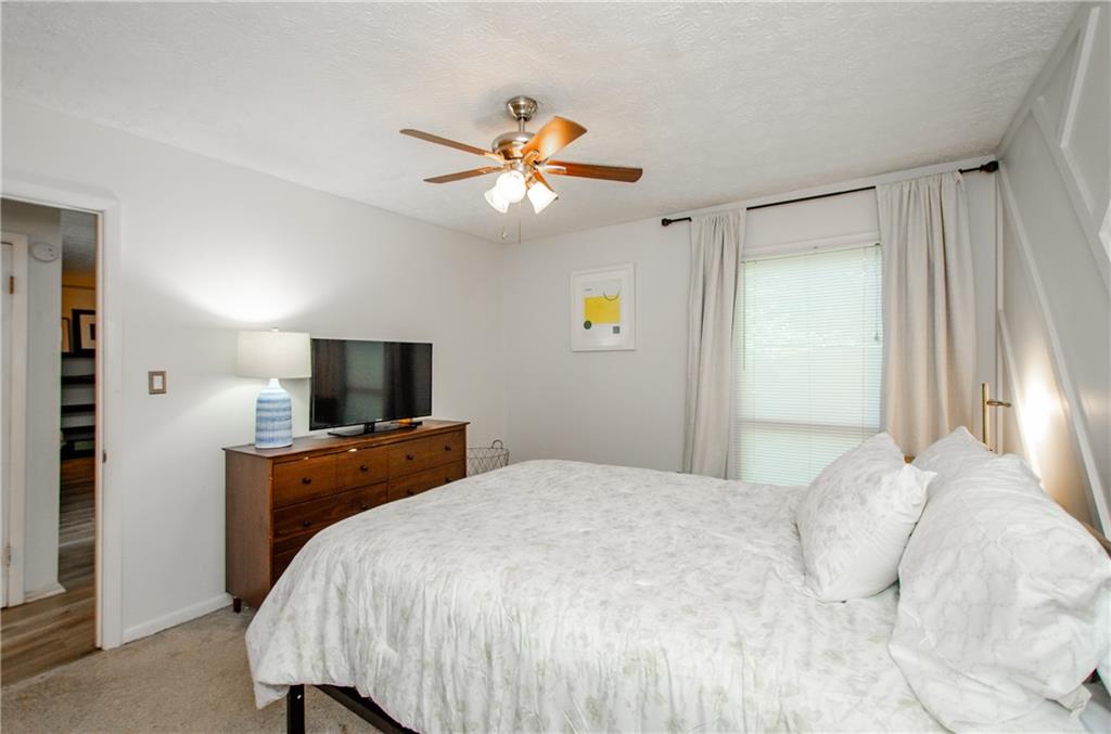 5157 Roswell Road, Unit 2 Atlanta, GA 30342 - Photo 18 of 24 a bedroom with a bed and a flat tv screen on dresser