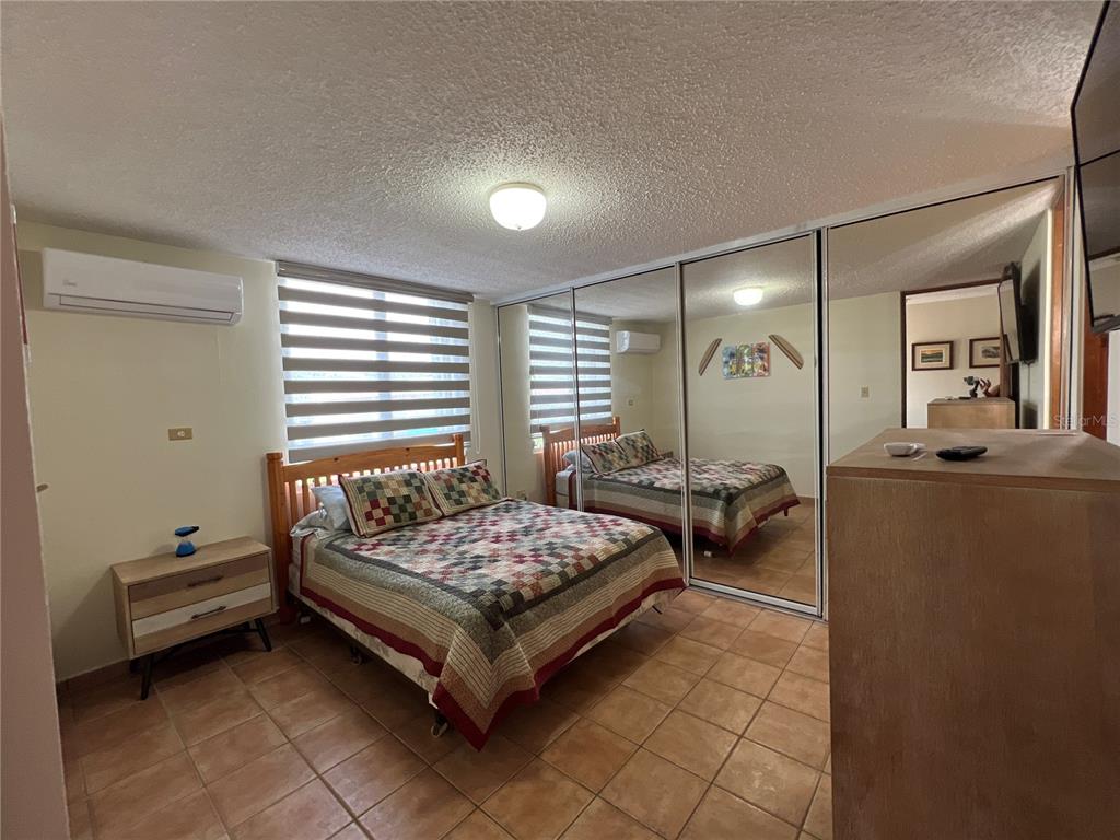 968 Camino Las Picüas, Unit 30 Rio Grande, Río Grande 00745 - Photo 19 of 24 a spacious bedroom with a bed and a mirror