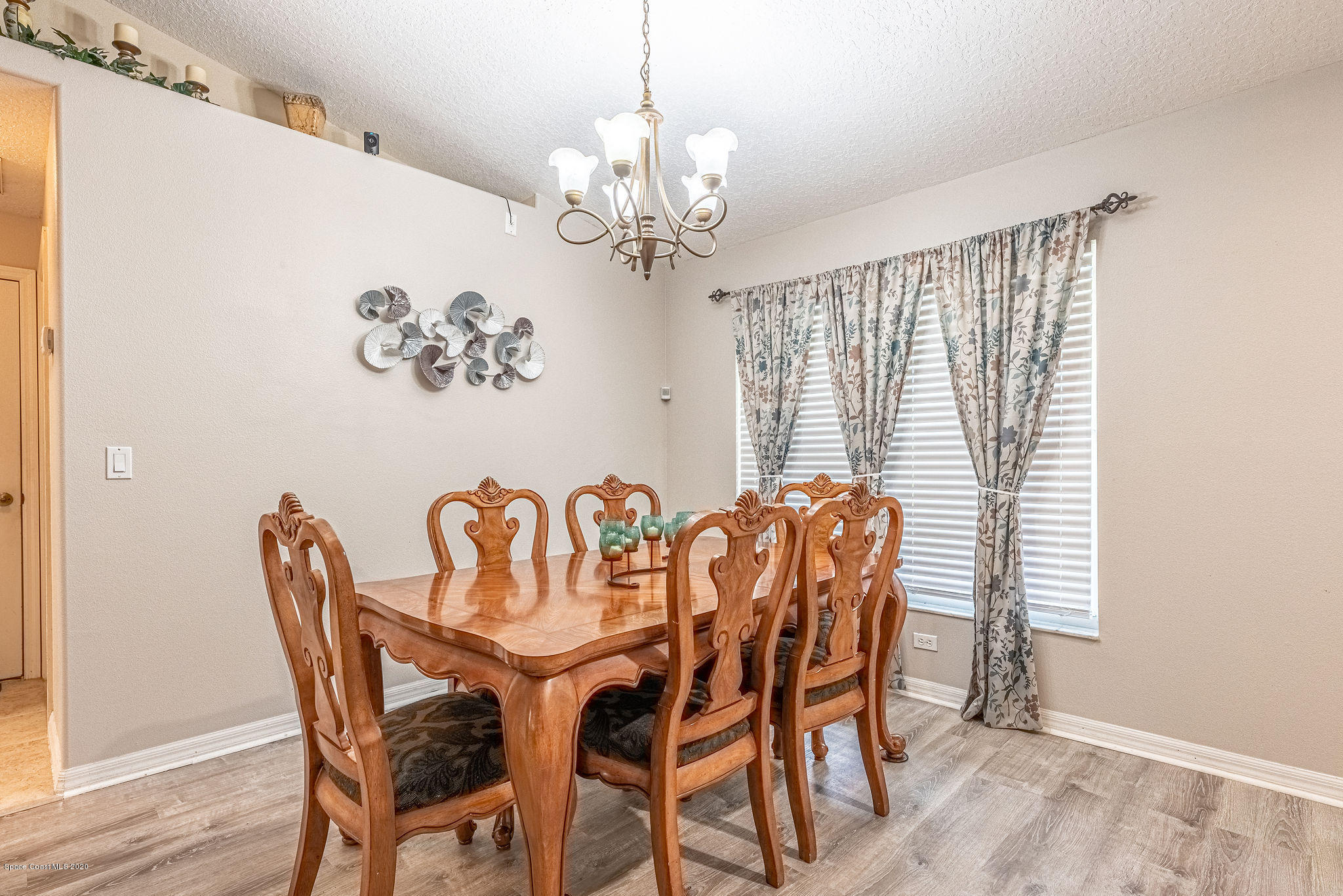 1253 Haulover Road Southwest Palm Bay, FL 32908 - Photo 17 of 52 a dining room with furniture a chandelier and wooden floor