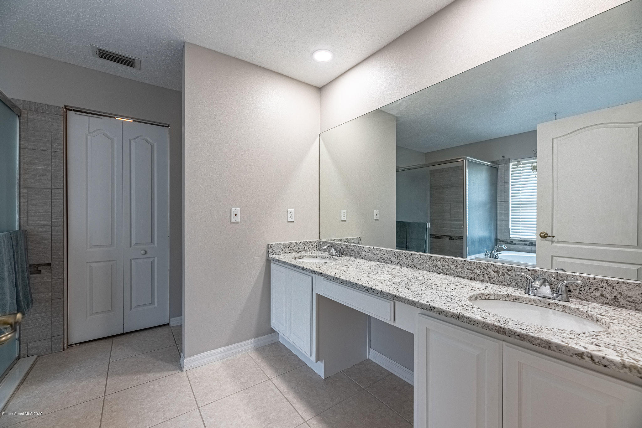1253 Haulover Road Southwest Palm Bay, FL 32908 - Photo 22 of 52 a bathroom with a granite countertop sink and a mirror
