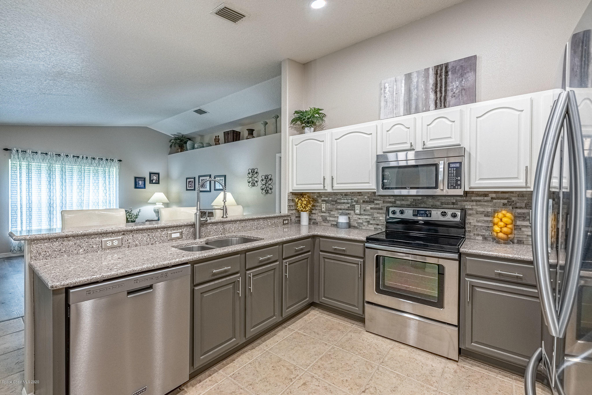1253 Haulover Road Southwest Palm Bay, FL 32908 - Photo 25 of 52 a kitchen with stainless steel appliances granite countertop a sink stove and refrigerator