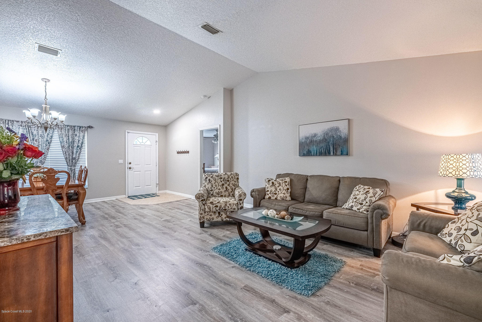 1253 Haulover Road Southwest Palm Bay, FL 32908 - Photo 28 of 52 a living room with furniture and a chandelier