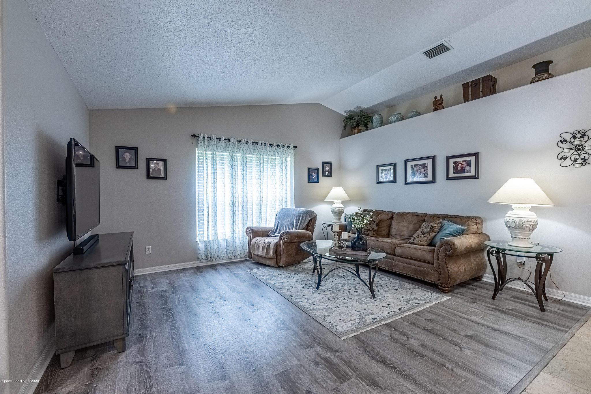 1253 Haulover Road Southwest Palm Bay, FL 32908 - Photo 30 of 52 a living room with furniture a flat screen tv and wooden floor